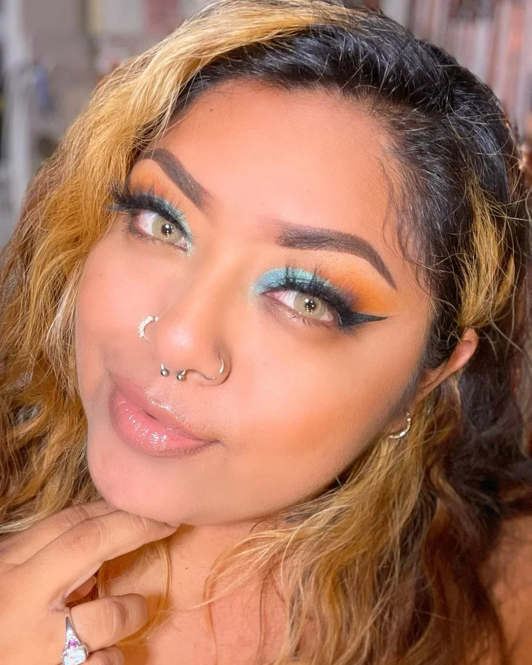 Selfie of a model wearing Say Yes Crush Brown lenses, creating a vibrant and confident look with radiant skin and colorful makeup.