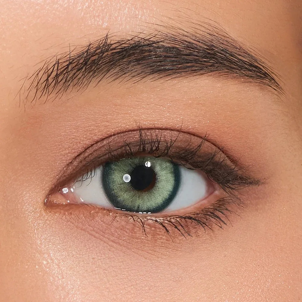 Close-up of eye wearing VISKON Emerald Green contact lenses with a bright green iris effect