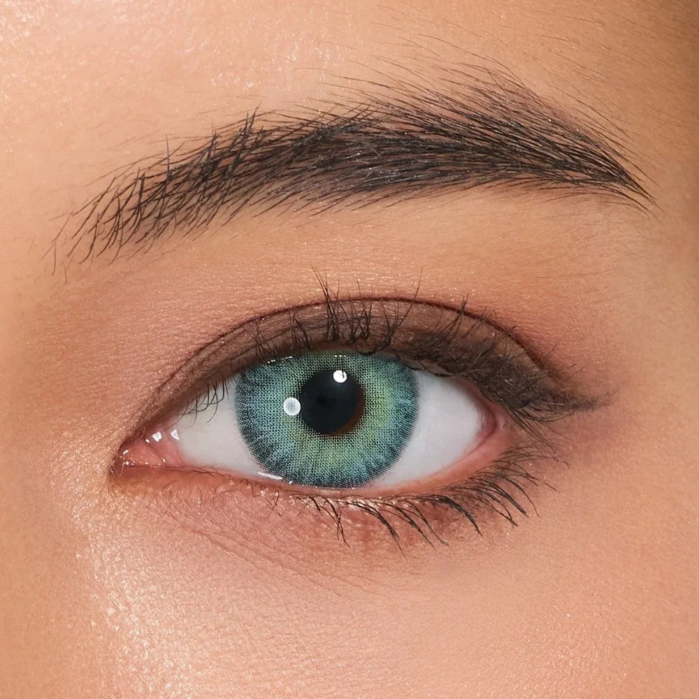 Close-up of eye wearing Horizon Blue colored contact lens from HoneyColor, features vibrant blue-green gradient with natural blending and enlarging graphic diameter for a bold, yet realistic look