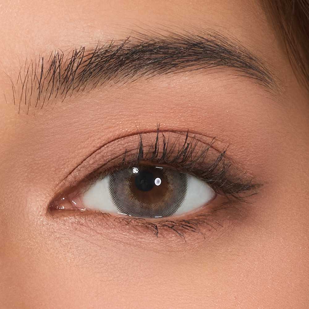 Close-up image of a human eye wearing a contact lens with a gray color, showcasing the Viskon Celebriti Collection.