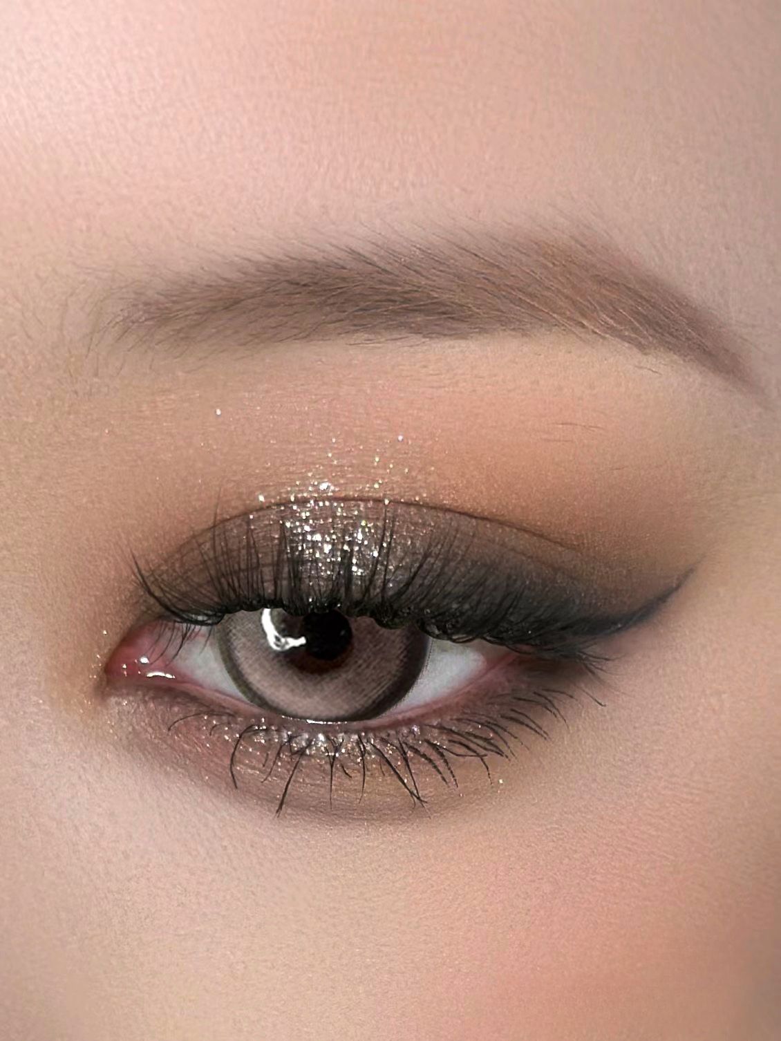 Close-up of a model wearing Caramel Pink Chic lenses with glittery eye makeup, showcasing soft pink and natural design.