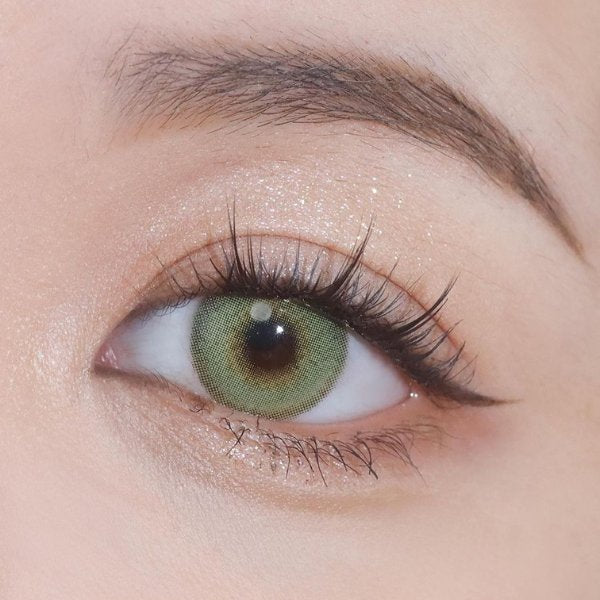 Close-up shot of an eye wearing Say Yes Dancing Green lenses, emphasizing their vibrant green color and detailing.