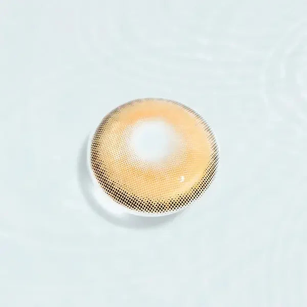 Single Say Yes Crush Brown lens displayed against a water-like background, emphasizing the brown and gold color pattern.