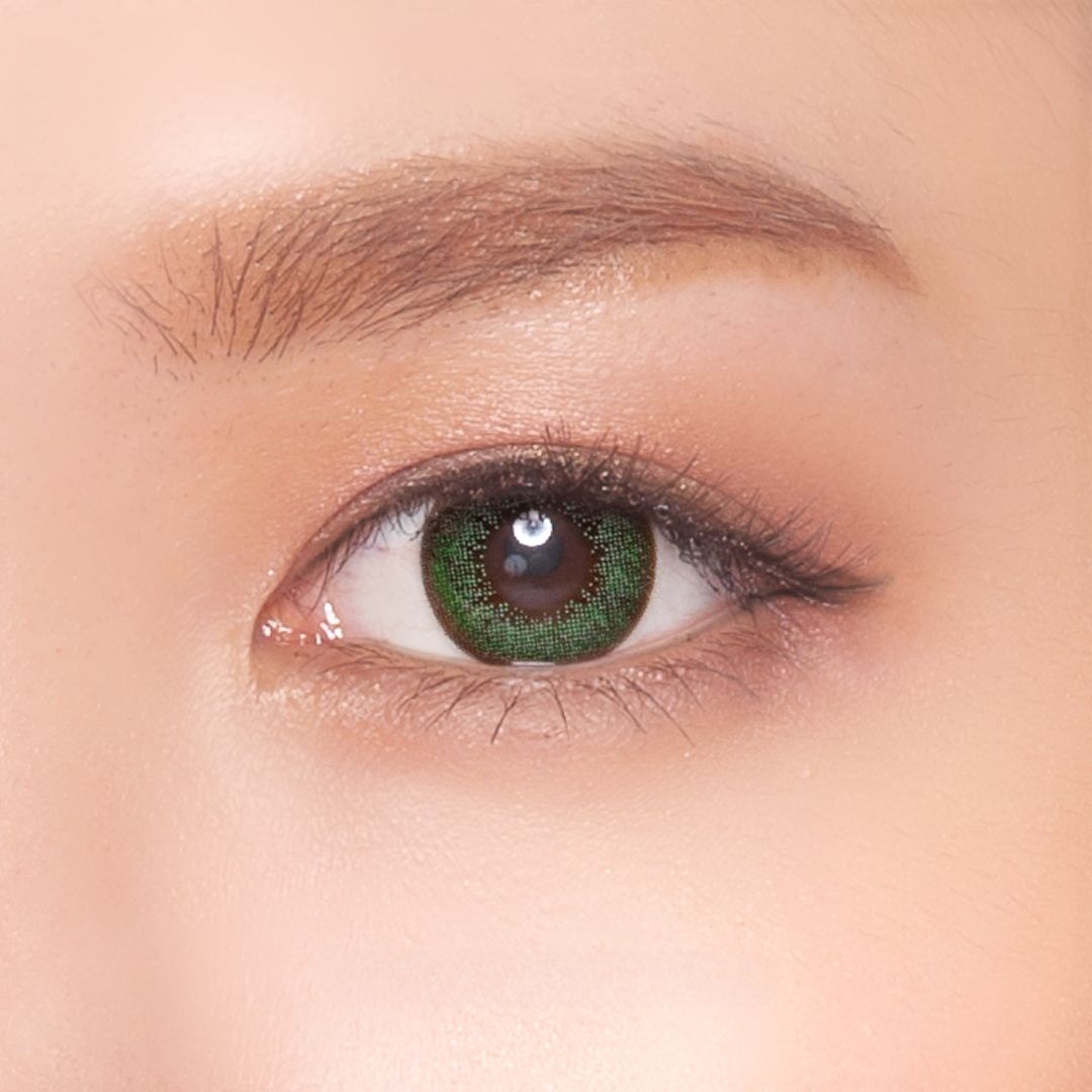 Close-up of a model's eye wearing Neo Dali Extra Green contact lenses, featuring a vivid green hue for a bold, eye-catching look.