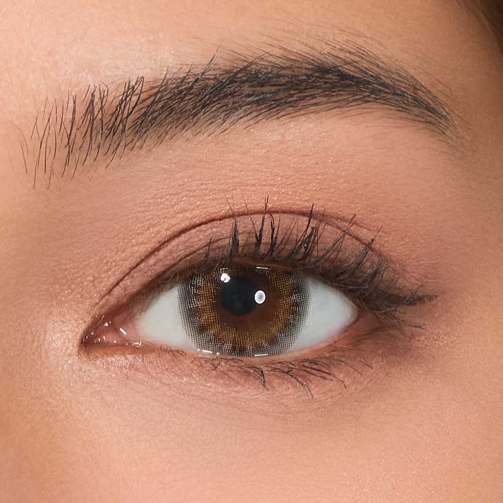 Close-up image of a human eye wearing a contact lens with a gray color, showcasing the Viskon Celebriti Collection.