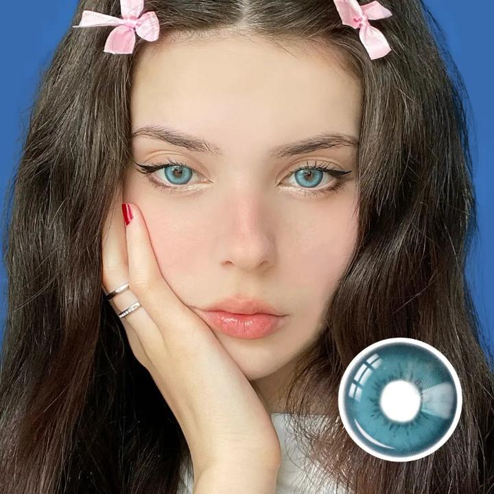 Model wearing Charisma Blue contact lenses, showing bright icy blue color with a natural finish