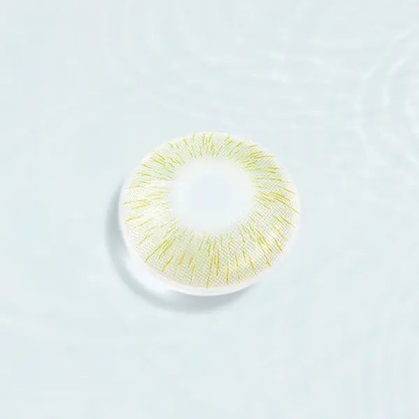 Single Perfect Hue Meloni Green lens displayed against a water-like background, emphasizing the unique green and yellow pattern.